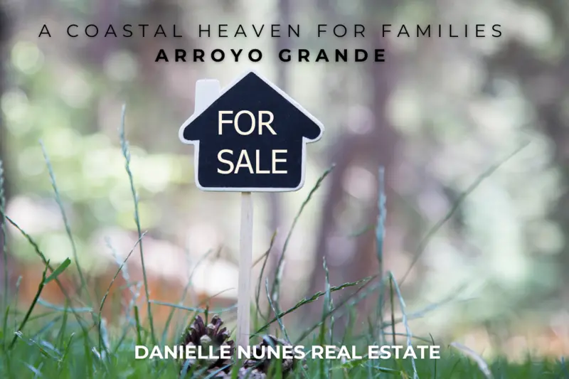 A close-up photograph of grass and a pine cone with a blurred hillside in the background. A small 'For Sale' sign shaped like a house silhouette is visible, evoking a real estate theme. Caption: Coastal Living for Families. Arroyo Grande. Danielle Nunes Real Estate.